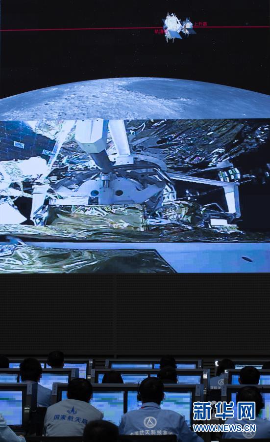 北京宇宙飛行制御センター指揮ホールで6日に撮影された、嫦娥5号の上昇モジュールが軌道モジュールと帰還モジュールの結合体とランデブー?ドッキングする様子