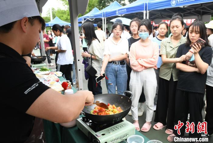 コンテスト会場で料理の腕を披露し、人々の注目を集めた大学生（撮影?周毅）。