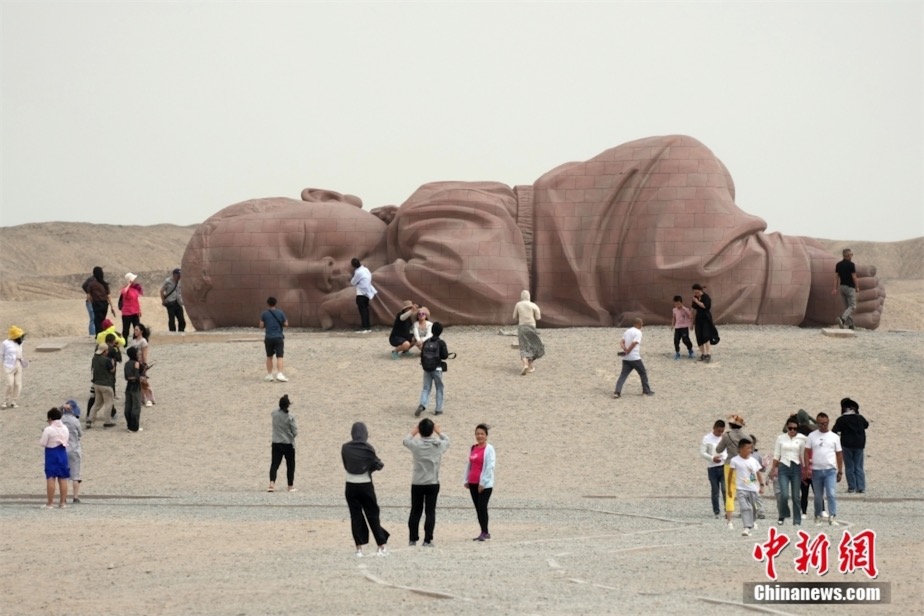 瓜州戈壁国際雕塑アートギャラリーで、大型彫刻作品「大地の子」を鑑賞する観光客（8月30日撮影?毛建軍）。